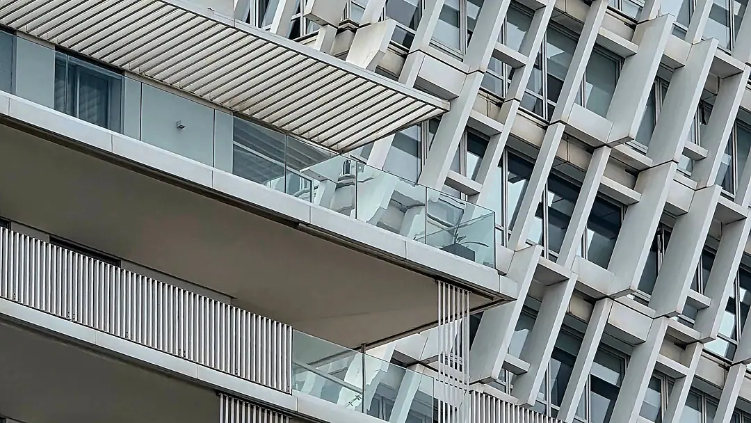 A new residential tower in Casablanca wrapped in a white concrete lattice, balconies cut into the screen
